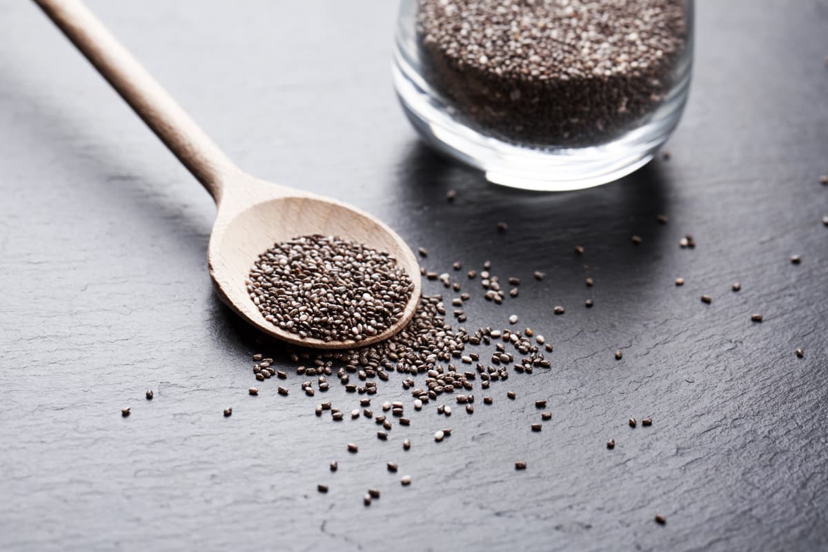 Chiasamen in einem Glas und auf einem Löffel.