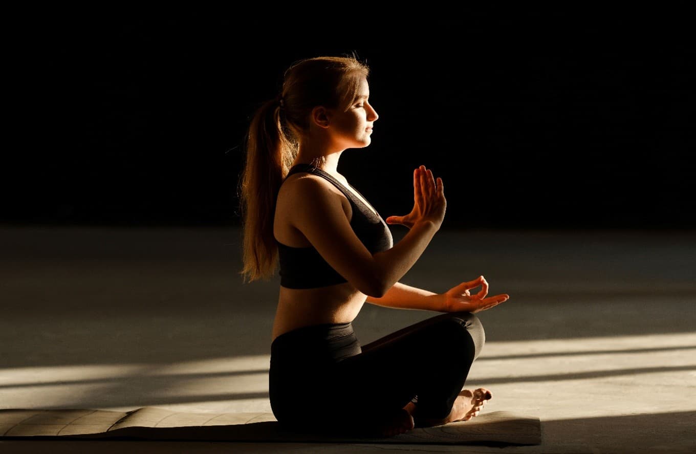 Frau, die auf dem Boden sitzt und meditiert 