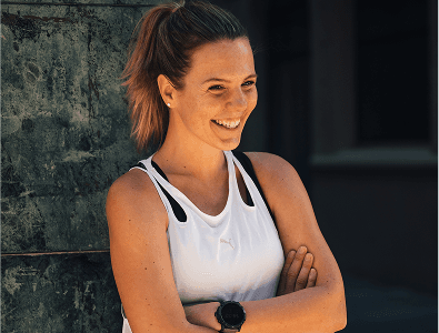 Joyce lächelnd in einem weißen Tanktop