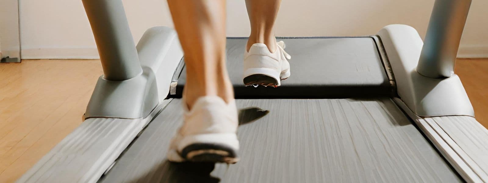 Person mit weißen Laufschuhen auf Laufband